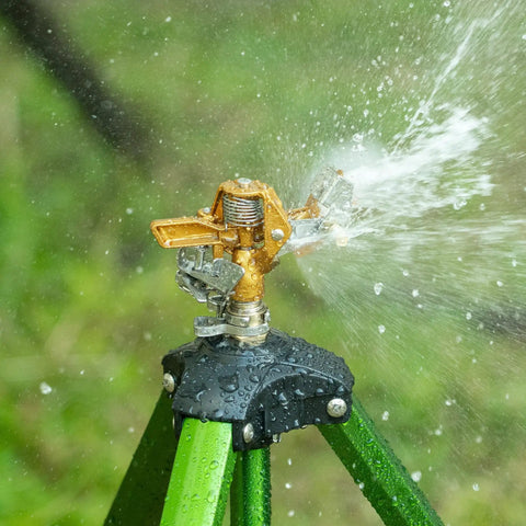 Heavy Duty Brass Impact Sprinklers Deliver Sick Durability, adjustable rotation, sprinkling water across a lush green background.