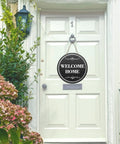 Six Round Sublimation Door Hanger Blanks For DIY Wall Decor on a white door with 'Welcome Home' message