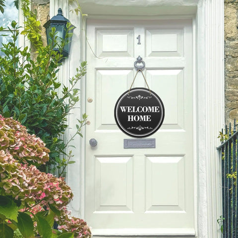 Six Round Sublimation Door Hanger Blanks For DIY Wall Decor on a white door with 'Welcome Home' message