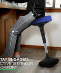 Active Standing Desk Stool With Flexible Seating For Office And Classroom Ergonomic Wiggle Chair That Keeps You Moving Adjustable Height Office Stool ADHD Friendly Posture Boosting Game Changer All Day Comfort. Person sitting on ergonomic blue seat with angled legs; black base in office setting.