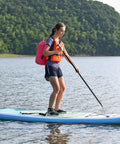 Paddleboarder with Floating Waterproof Dry Bag Backpack 10L Pink For Kayaking Rafting Boating And Outdoor Adventures on serene water