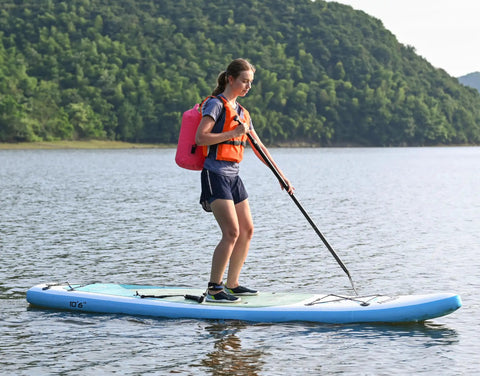 Paddleboarder with Floating Waterproof Dry Bag Backpack 10L Pink For Kayaking Rafting Boating And Outdoor Adventures on serene water