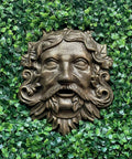 Top Tier Green Man Wall Decor, Slick 9.75 Inch Heavy Duty Cast Iron Plaque, Solid Bronze Finish on greenery background.