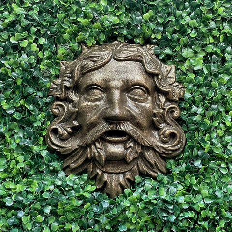 Top Tier Green Man Wall Decor, Slick 9.75 Inch Heavy Duty Cast Iron Plaque, Solid Bronze Finish on greenery background.