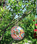 6 Inch Glass Mosaic Hanging Bird Feeder For Outdoors With Fly Through Opening Confetti Mosaic against a tree backdrop