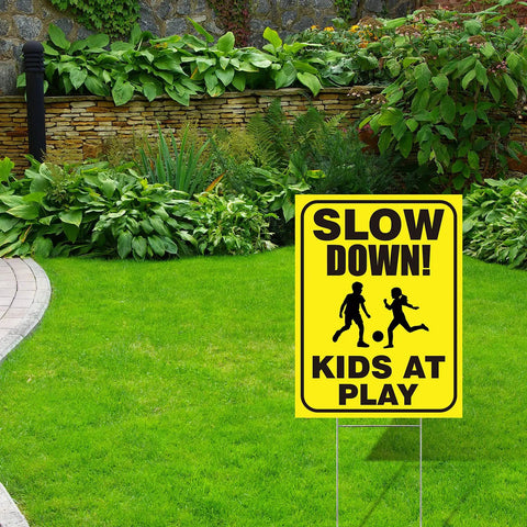 Slow Down Kids At Play Signs With Metal Stakes Four Pack 12 By 16 Inch Double Sided Caution Signs in a garden yard