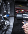 Heavy Duty Half Inch Impact Wrench With 2 Inch Extended Anvil And Twin Hammer For Deep Tire Wells being used on car tire