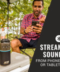 Man using OneSource Rechargeable Camping Gear Set With Camp Shower Cordless Vacuum Portable Fan Bluetooth Speaker And Air Pump Powered By A Single Battery System For All Day Power On The Go with speaker.