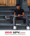 Musician using MPK Mini MK3 25 Key USB MIDI Keyboard Controller with 8 backlit drum pads and 8 knobs outdoor setup