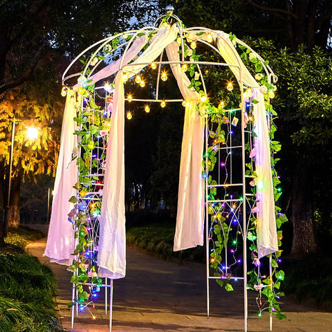 Birdcage Garden Arch Arbor 9 Ft High By 6.8 Ft Wide White Metal Gazebo With Anti Rust Wrought Iron Frame adorned with lights and fabric.