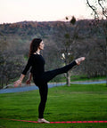 Person balancing on Slackline Kit With Overhead Training Line in a park setting.