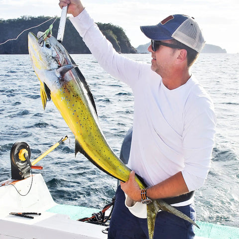 Angler holding a large fish on a boat, demonstrating effective use of 600 Piece Aluminum Fishing Crimp Sleeves Kit