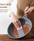 Person cleaning Kickin Nonstick Frying Pan With Swiss Granite Coating For Effortless Omelets And Everyday Cooking PFOA Free Stone Cookware
