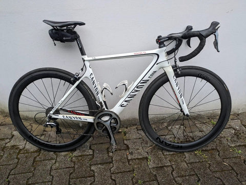 Ultra Light Carbon Road Wheelset 700C Rim Brake bike parked on pavement with 20 to 24 holes and premium hubs visible.