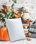 Bubble Mailers 8.5x12 Inch White Pack Of 25, Usable Inner 8.5x11, displayed with autumn decor and books.