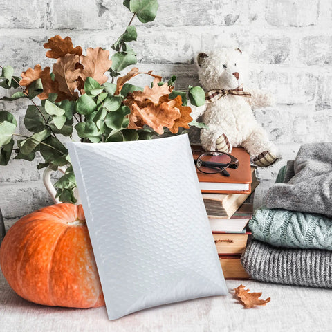 Bubble Mailers 8.5x12 Inch White Pack Of 25, Usable Inner 8.5x11, displayed with autumn decor and books.