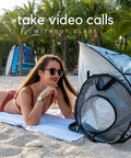 Woman using Outdoor Laptop Sun Shade For Working Anywhere Glare Blocker And Heat Reflective Hood Portable Privacy Tent on beach