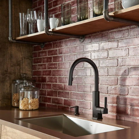 Slick Matte Black Deck Mounted Soap And Lotion Dispenser Pump beside modern faucet in kitchen setting.