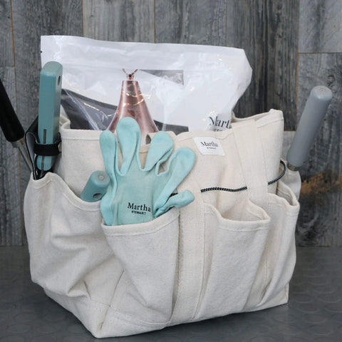 Heavy-Duty Canvas Garden Bag With 6-Inch Exterior Pockets And 11-Inch Interior Pockets filled with gardening tools.