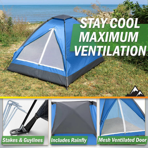 Blue two-person camping tent with rain fly on grassy field near beach, includes stakes and guy lines, mesh door for ventilation.