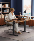 Woman using Huuger 47 X 24 Inch Height Adjustable Electric Standing Desk In Rustic Brown, ergonomic home office setup.