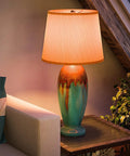 Cozy living room with colorful vase lamp on side table, ambient lighting and greenery