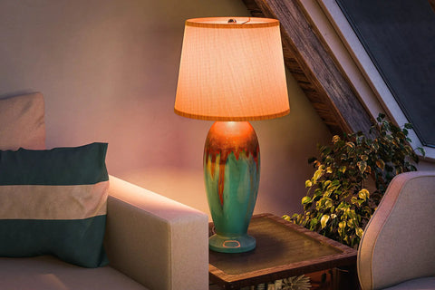 Cozy living room with colorful vase lamp on side table, ambient lighting and greenery