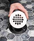 Rock Solid Universal Shower Drain Strainer In Durable White Plastic Snap Tite Cover fits 2 or 3 inch drains over hexagon tile floor.