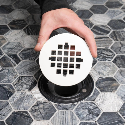 Rock Solid Universal Shower Drain Strainer In Durable White Plastic Snap Tite Cover fits 2 or 3 inch drains over hexagon tile floor.