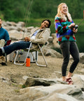 Group of people fishing by a river, one holding a Roam Size 30 Spincast Fishing Reel With Pre Spooled 10 Pound Line Right Or Left Hand Retrieve Built To Last Beefy Stainless Front Cover No Tangle Design Dual Ceramic Pickup Blue.