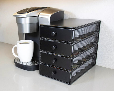 Black Satin 4 Tier Coffee Pod Drawer Organizer with K-Cups beside a coffee maker on a kitchen countertop.