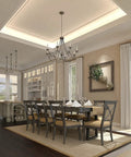Elegant dining room with chandelier, dark wood table, and chairs next to large windows and decor. Ideal for gatherings.