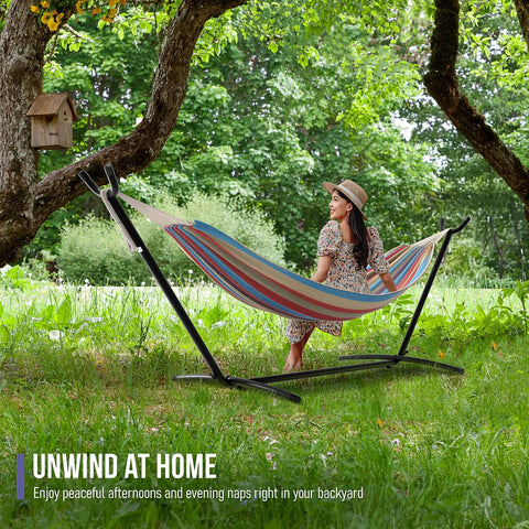 Two Person Luxury Hammock With Steel Stand Portable 450 Lbs Capacity Cotton Blend 60 Inch Bed in a backyard garden