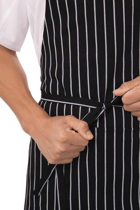 Person tying waist of durable unisex kitchen apron with reinforced stress points and comfy waist tie for men and women.