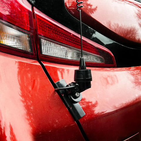 Premium NMO Lip Mount for Antennas, Multi-Axis Adjustable No-Drill Rig Mount attached on a red car trunk with antenna wire.