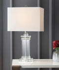 Ophelia Clear Solid Crystal LED Table Lamp With White Linen Shade, Modern Rectangular Column Design, displayed on table.