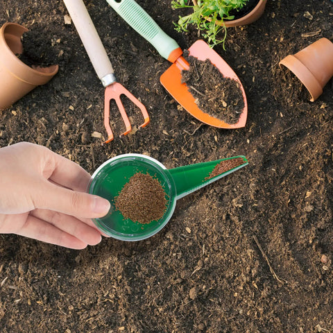 Hand holding Compact Handy Seed Spreader Handheld Planter Tool For Tiny Seeds Portable Mini Garden Seeder over soil
