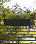 Badass Weatherproof Railing Planter Box With Secure Mounting Bracket, 36x8.5 inches, black, holding grass, mounted on a railing outdoors.