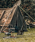 18 Inch Military Folding Camping Shovel next to a tent, olive green high carbon steel, perfect for camping and survival