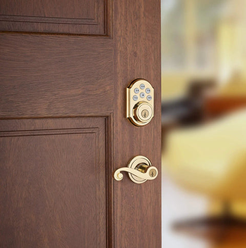SmartCode 910 Z Wave Plus Deadbolt With Keyless Entry And Illuminated Keypad on wooden door, polished brass finish