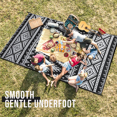 Family picnic on Waterproof Reversible Outdoor Rug 5x8 Ft Made From Recycled Plastic Straws Dope Boho Black And White Patio Carpet
