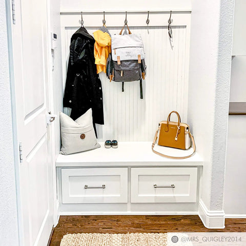 White entryway with coat hooks, bags, and Milano 10 Pack Matte Black Door And Drawer Pulls, 6 Inch Center To Center Cabinet Hardware.