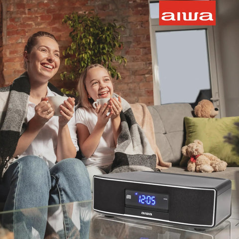 Two people enjoying music from Exos Home Speaker With 30W RMS Power, Bluetooth Streaming, CD Player, FM Radio on a coffee table.