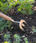 Stainless Steel Hand Weeder Fork For Easy Weeding And Soil Aeration, Durable Gardening Tool with Ergonomic Handle in use on garden bed