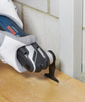 Starlock Oscillating Multi Tool Accessory Kit 26 Piece Set in use for precise cutting on wood floor by wall.