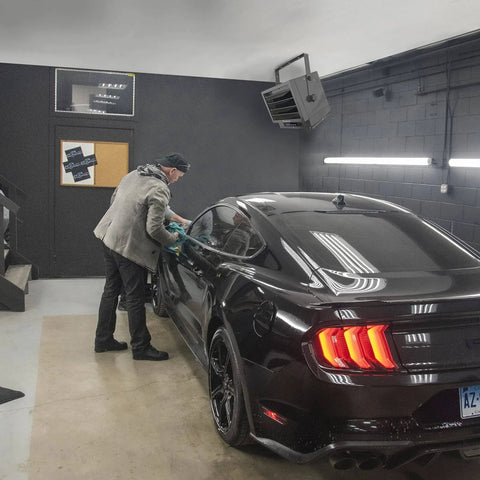 Hard Wired Ceiling Mount Garage Heater With Remote 7500 Watt 240 Volt Fan Forced Heat Overheat Protection Digital Thermostat 12 Hour Timer Space Saving Garage And Workshop Heating Toasty installed in garage ceiling above a car detailing workspace.