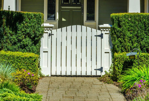 White garden gate with greenery, suitable for Automatic Gate Latch 4 13/16 Inch Black Steel Self Latching Reversible For Right Or Left Handed Gates.