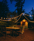 100 Foot Outdoor String Lights With 105 G50 Clear 2 Inch Bulbs On Black Wire Includes 5 Extra Bulbs illuminating patio area at night