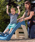Child sliding down a blue and beige Play And Fold Junior Slide For Toddlers 1.5 To 4 Years Old Indoor Outdoor Backyard Playground Set