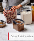 Person organizing kitchen with Clear 32oz Cereal Storage Container with Airtight Seal, Shatterproof Tritan, BPA Free.